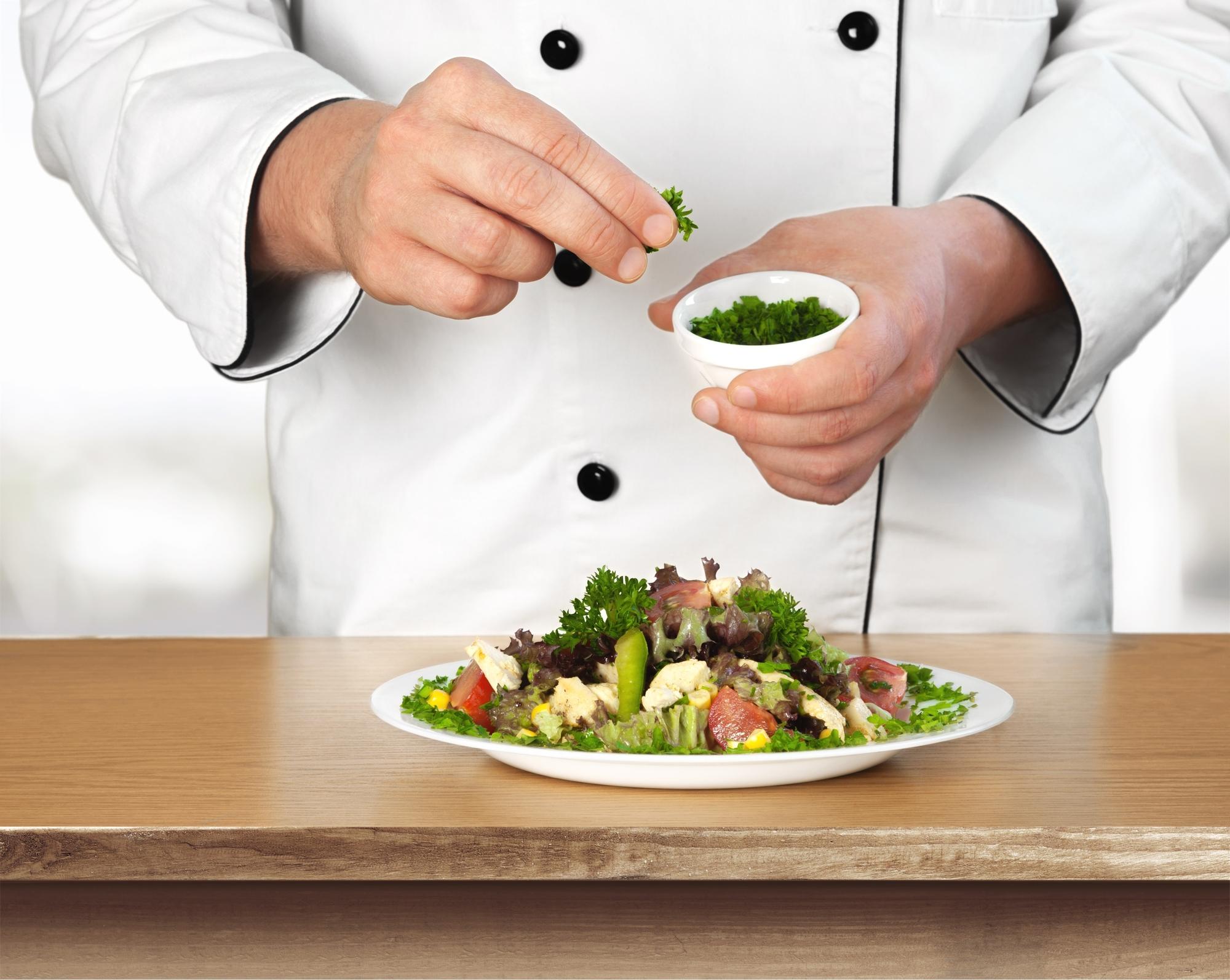 Chef finishing a plated vegetable course